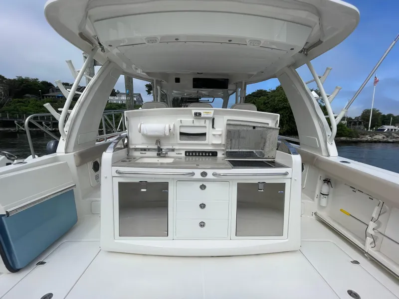 Slide: The Image of 2017 Boston Whaler 420 Outrage boat interior with kitchenette and storage cabinets. - 5