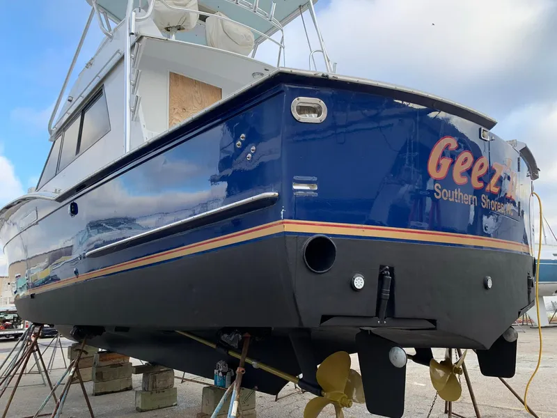 Slide: The Image of 1980 Hatteras 46 Convertible boat on stands, blue hull, visible propellers. - 11