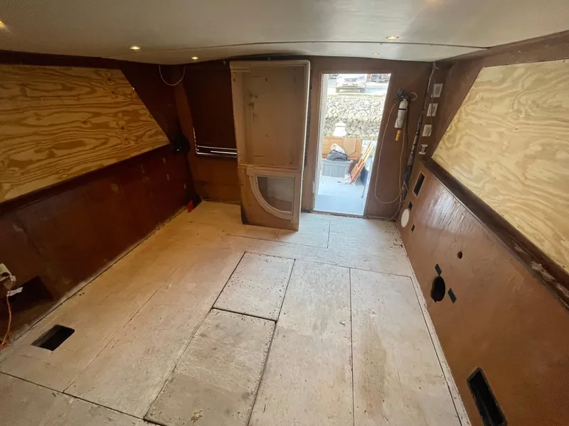 Slide: The Image of Interior of a 1980 Hatteras 46 Convertible boat under renovation, showing unfinished wooden panels. - 22