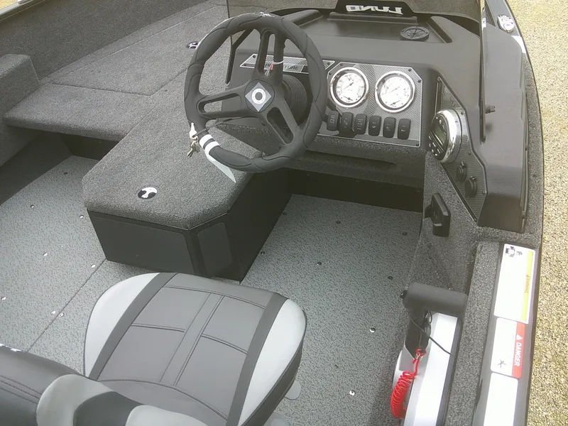 Slide: The Image of 2025 Lund 1775 Adventure SS boat interior with steering wheel and dashboard controls. - 9
