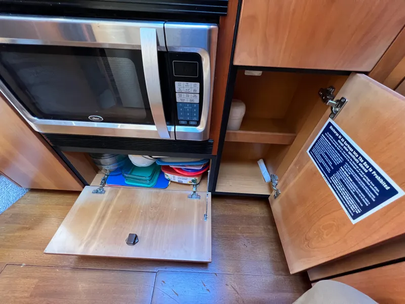 Slide: The Image of Kitchen area of 2008 Sunseeker Manhattan 50 yacht with microwave and open cabinets. - 40