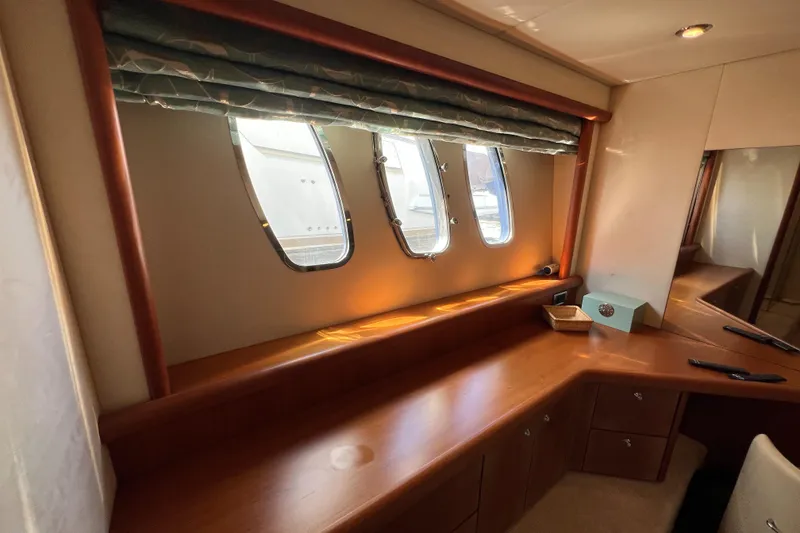 Slide: The Image of Interior of 2008 Sunseeker Manhattan 50 yacht, featuring a wooden desk and porthole windows. - 48