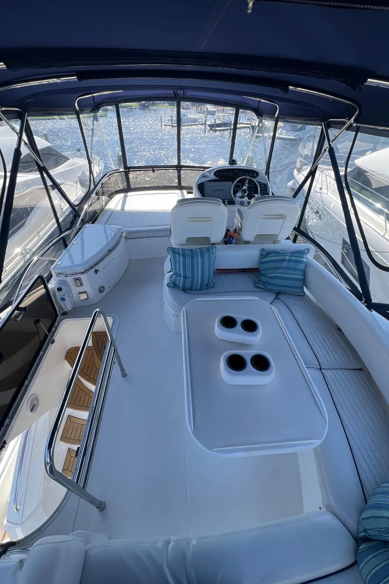 Slide: The Image of 2008 Sunseeker Manhattan 50 yacht interior with seating and helm, featuring blue cushions. - 7