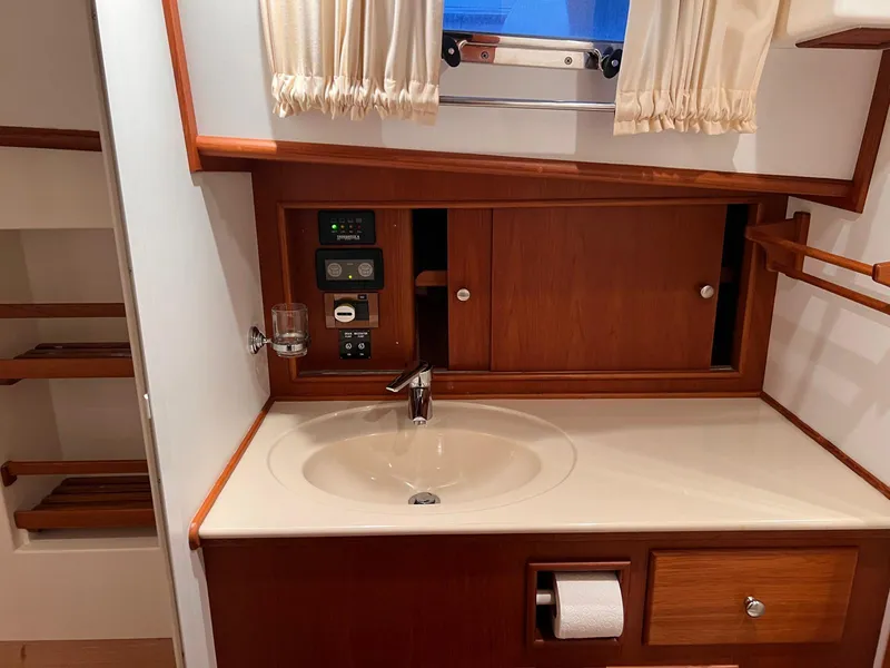 Slide: The Image of Luxurious 2004 Grand Banks Eastbay 54 SX yacht bathroom with wooden cabinetry and modern fixtures. - 11