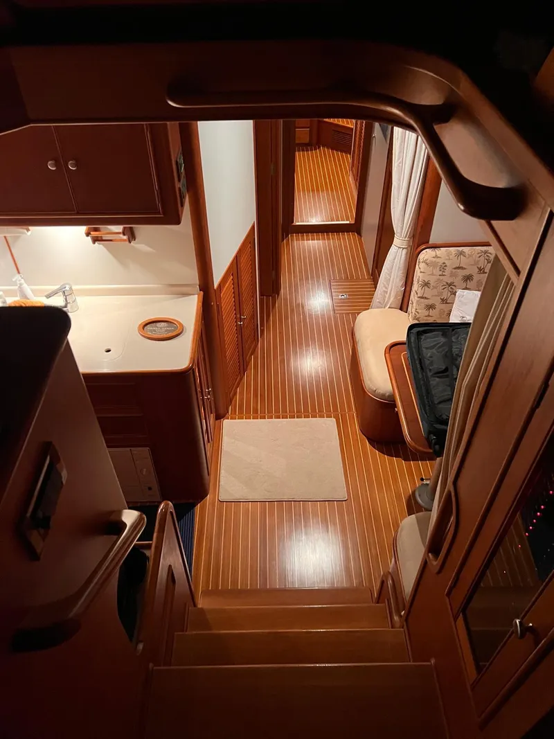 Slide: The Image of Interior of 2004 Grand Banks Eastbay 54 SX yacht, featuring wooden flooring and cozy seating area. - 14