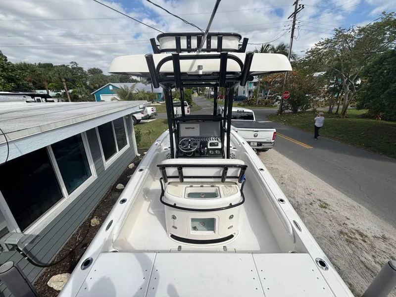 Slide: The Image of 2016 ShearWater 260 Carolina Bay boat with center console and T-top, parked near a house. - 11