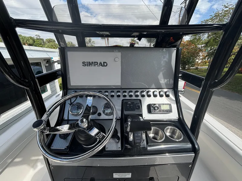 Slide: The Image of 2016 ShearWater 260 Carolina Bay boat console with Simrad display and steering wheel. - 14
