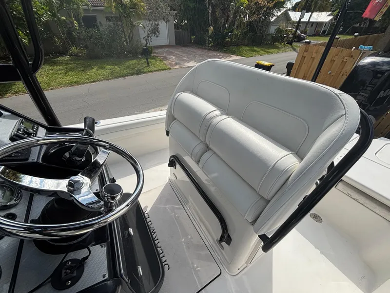 Slide: The Image of 2016 ShearWater 260 Carolina Bay boat interior with steering wheel and cushioned seating. - 15