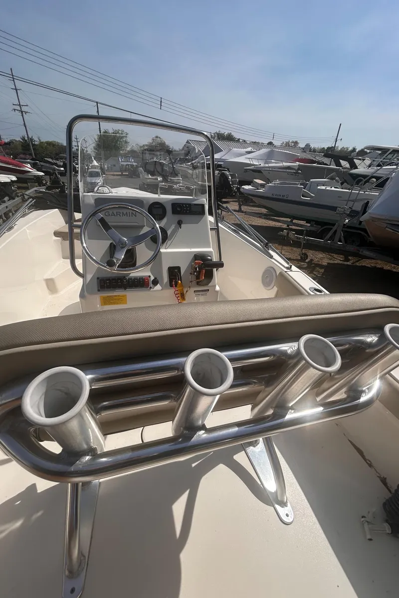 Slide: The Image of 2022 Key West 179FS boat with rod holders and steering console, docked under clear skies. - 3
