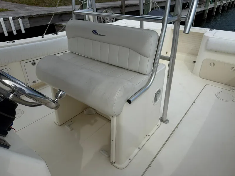 Slide: The Image of 2003 World Cat 330 TE boat interior with white cushioned seating. - 19