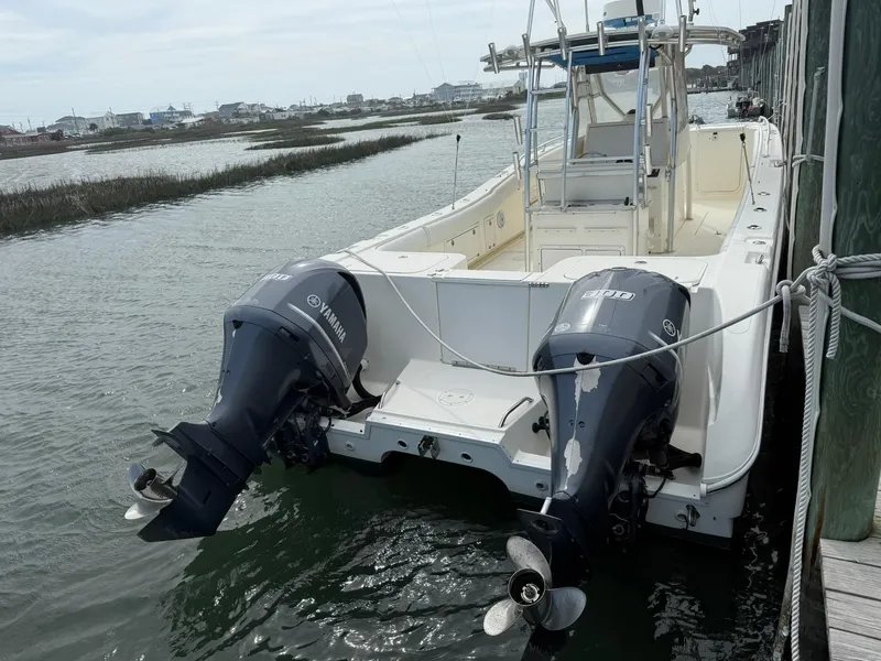Slide: The Image of 2003 World Cat 330 TE boat with dual Yamaha outboard motors docked by the water. - 23