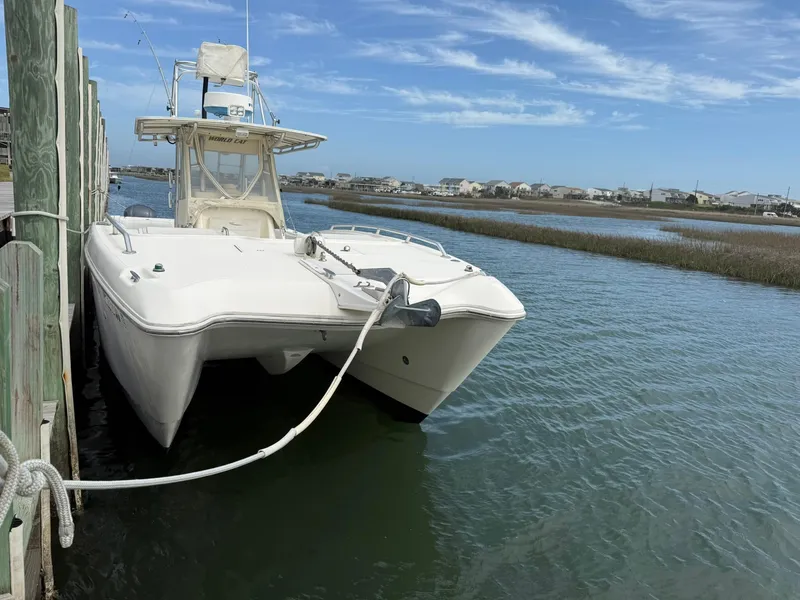 Slide: The Image of 2003 World Cat 330 TE boat docked in calm waters under a clear blue sky. - 5