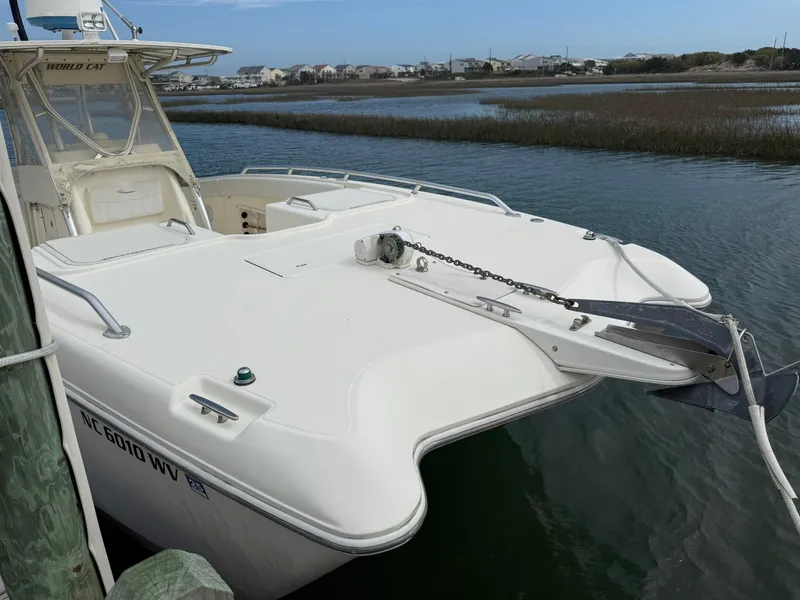 Slide: The Image of 2003 World Cat 330 TE boat docked on calm water. - 6