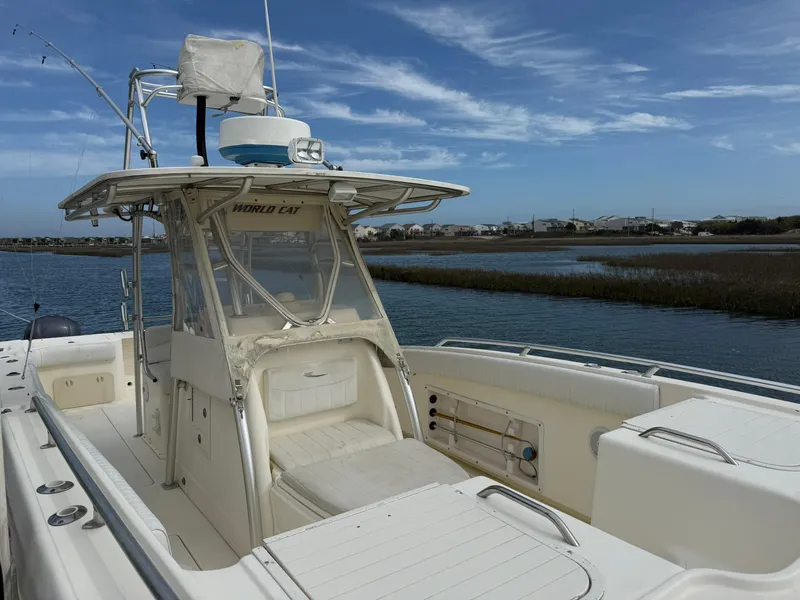 Slide: The Image of 2003 World Cat 330 TE boat on water, clear sky, spacious deck, fishing equipment. - 7