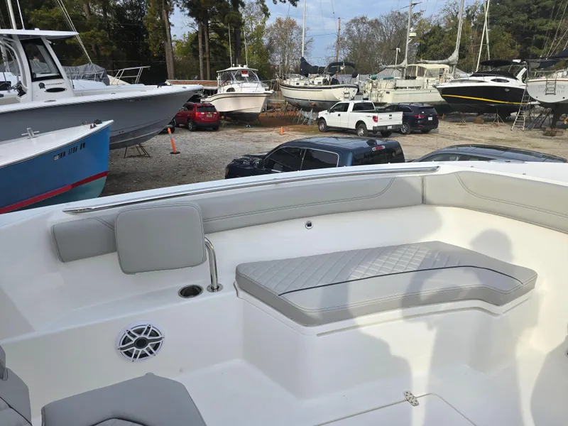 Slide: The Image of 2025 Pursuit S 288 boat interior with seating, parked in a marina with other boats. - 10