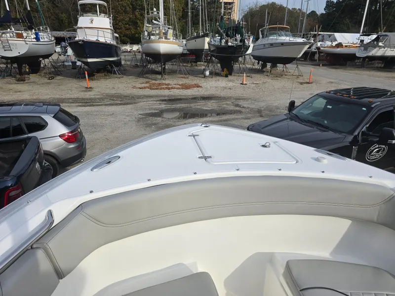 Slide: The Image of 2025 Pursuit S 288 boat in marina with parked cars and other boats. - 12