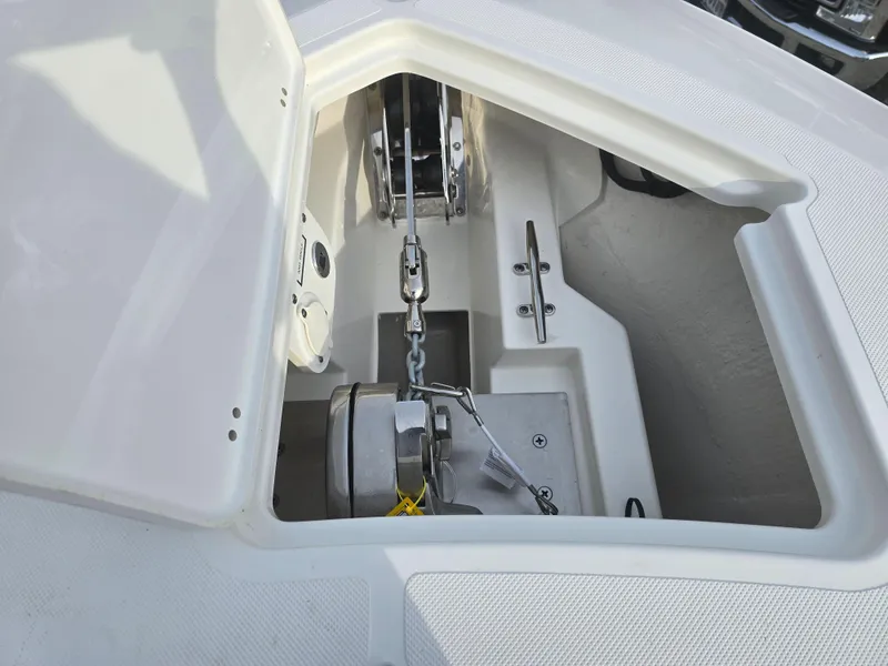 Slide: The Image of 2025 Pursuit S 288 boat anchor compartment with chain and winch system. - 13