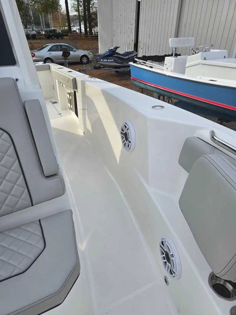 Slide: The Image of 2025 Pursuit S 288 boat interior with cushioned seating and speakers. - 18