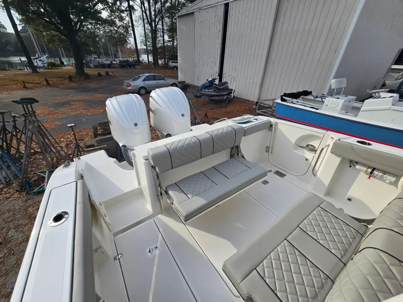 Slide: The Image of 2025 Pursuit S 288 boat with dual engines and spacious seating in a marina setting. - 24