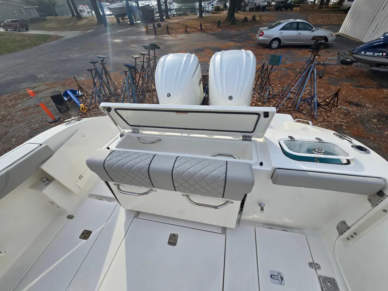 Slide: The Image of 2025 Pursuit S 288 boat with dual engines and cushioned seating in a marina setting. - 26