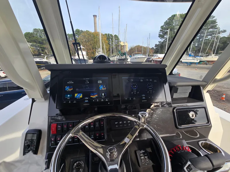 Slide: The Image of 2025 Pursuit S 288 boat dashboard with advanced navigation screens and steering wheel. - 27