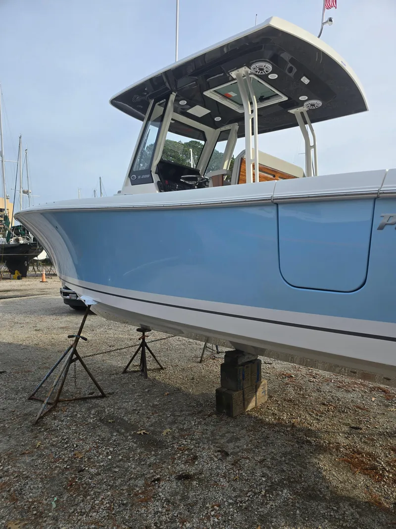 Slide: The Image of 2025 Pursuit S 288 boat in dry dock, blue hull, modern design. - 6