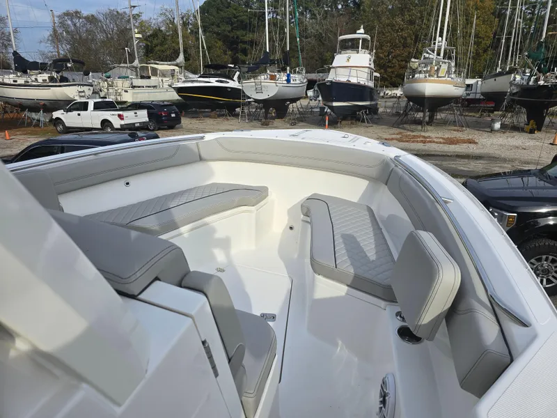 Slide: The Image of 2025 Pursuit S 288 boat with spacious seating, docked among other vessels. - 9
