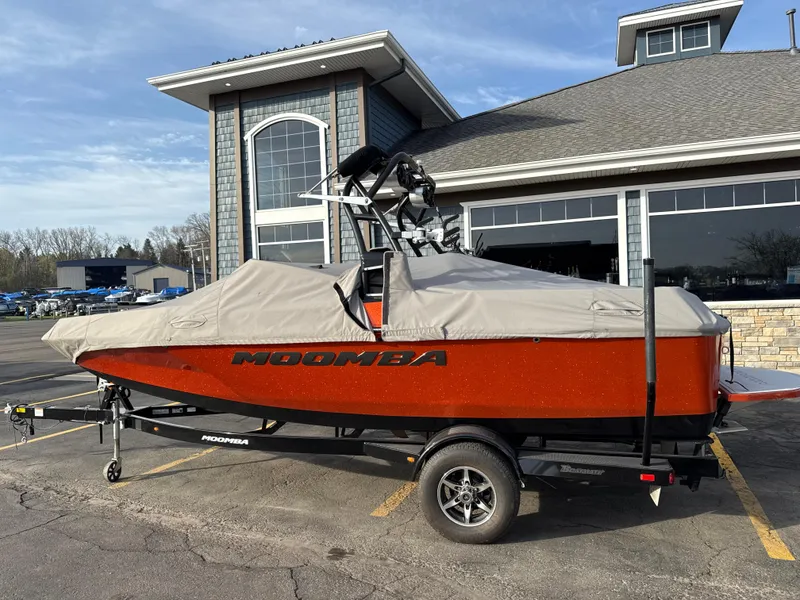Slide: The Image of 2018 Moomba Helix boat with cover on trailer, parked outside a building. - 0