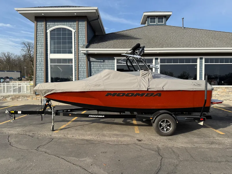 Slide: The Image of 2018 Moomba Helix boat with cover on trailer, parked in front of a building. - 1
