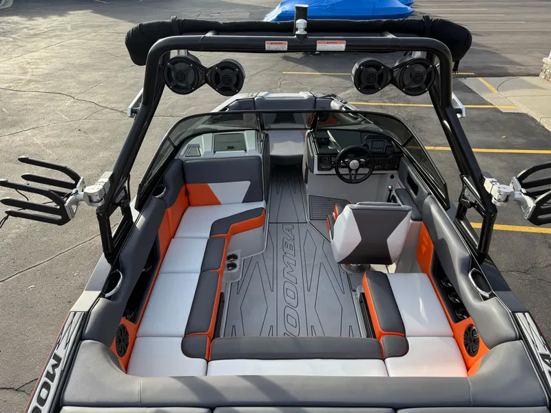 Slide: The Image of 2018 Moomba Helix boat interior with gray and orange seating, advanced sound system, and sleek design. - 10
