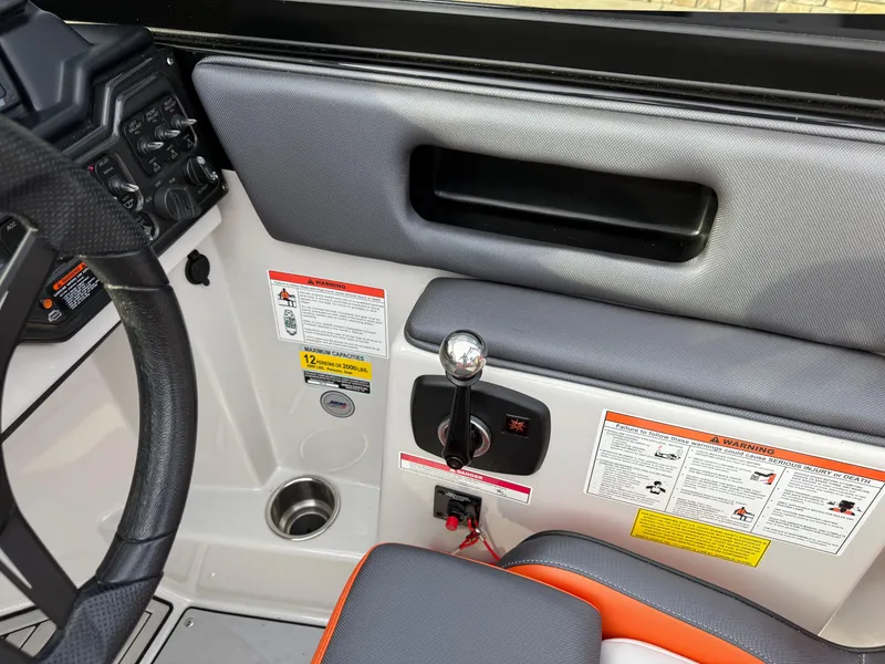 Slide: The Image of 2018 Moomba Helix boat interior with control panel and gear shift lever. - 17