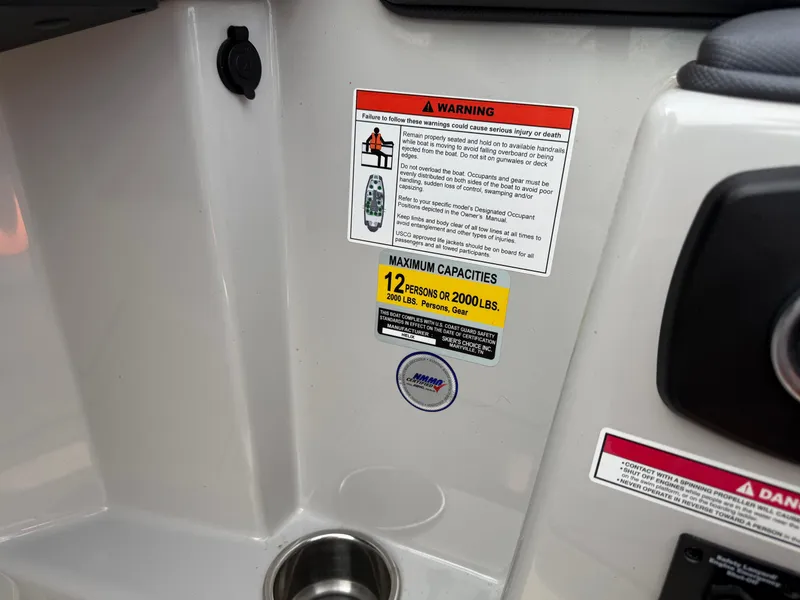 Slide: The Image of 2018 Moomba Helix boat capacity warning labels and cup holder. - 18