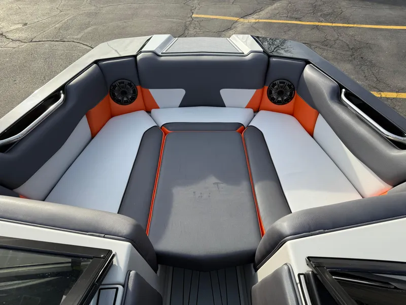 Slide: The Image of 2018 Moomba Helix boat interior with gray, white, and orange seating, featuring built-in speakers. - 20
