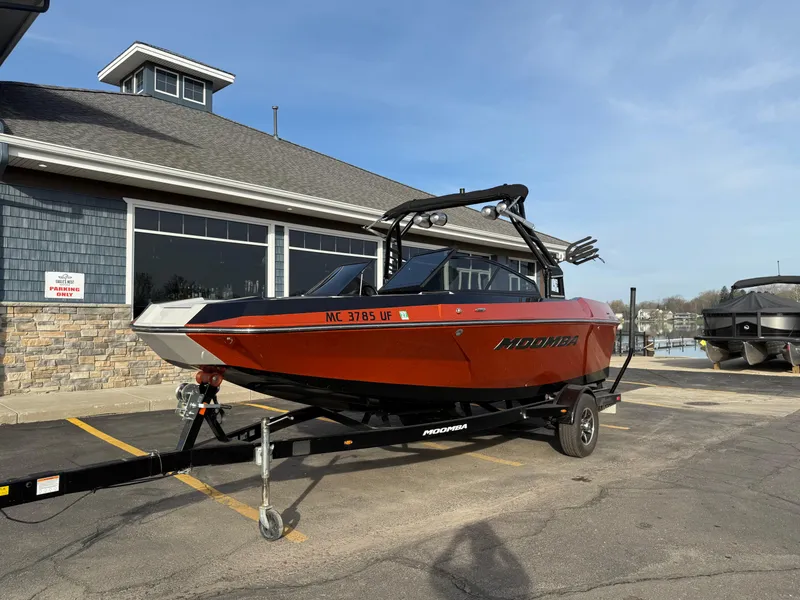 Slide: The Image of 2018 Moomba Helix boat on trailer, parked outside a building under clear skies. - 3