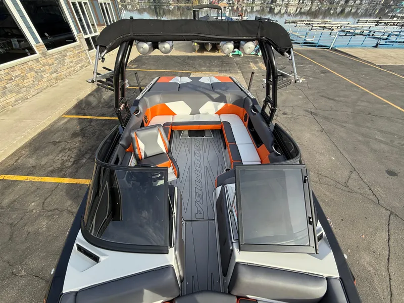 Slide: The Image of 2018 Moomba Helix boat with orange and gray interior, docked near a marina. - 39