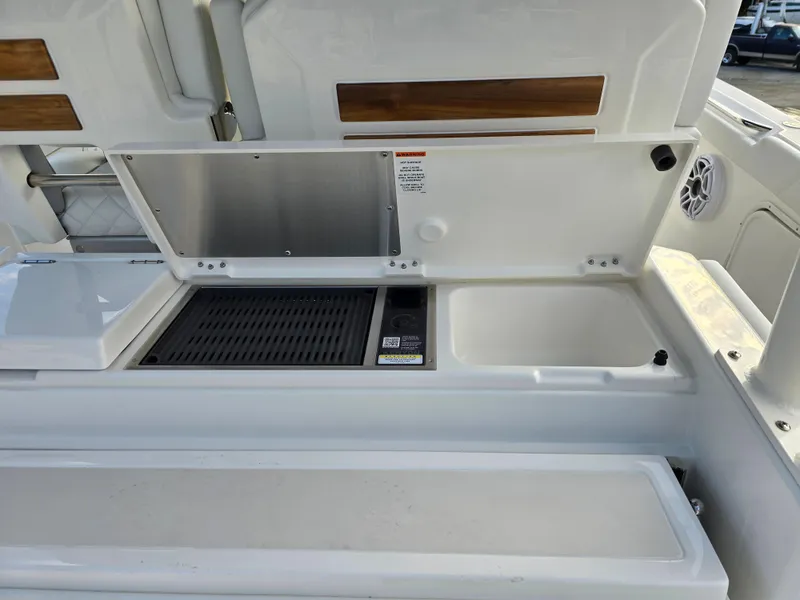 Slide: The Image of 2025 Pursuit S 328 boat interior with open storage compartments and grill. - 10
