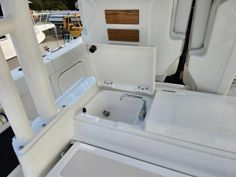 Slide: The Image of 2025 Pursuit S 328 boat interior with open storage compartment and sink. - 11