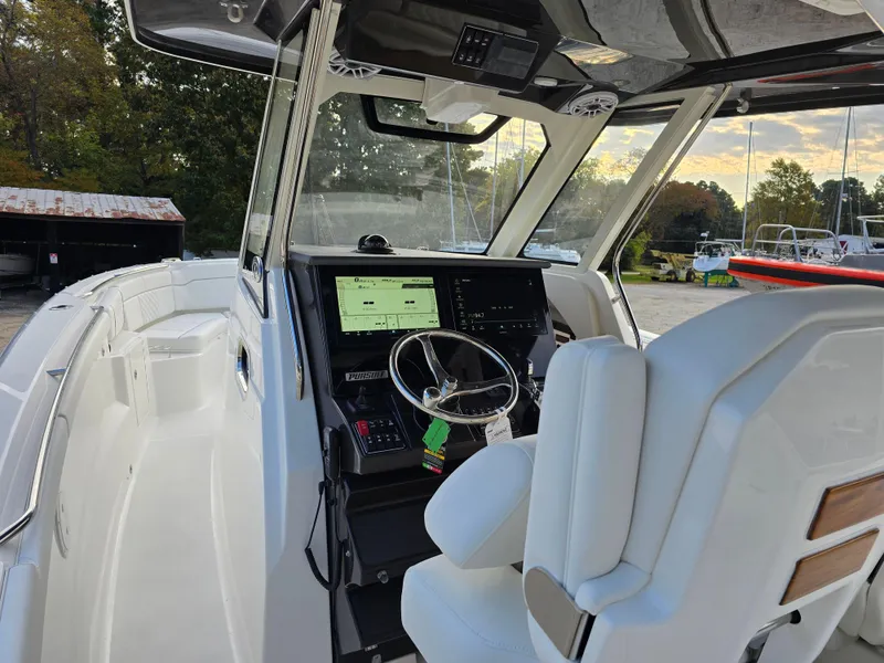 Slide: The Image of 2025 Pursuit S 328 boat cockpit with modern controls and steering wheel. - 12