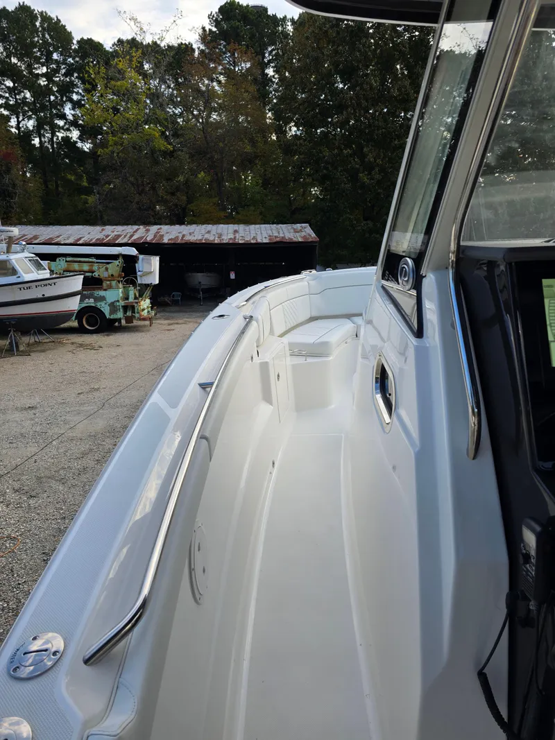 Slide: The Image of 2025 Pursuit S 328 boat docked, showcasing sleek design and spacious deck. - 13