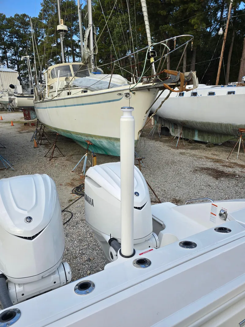 Slide: The Image of 2025 Pursuit S 328 boat with dual engines in a marina, surrounded by other boats. - 6