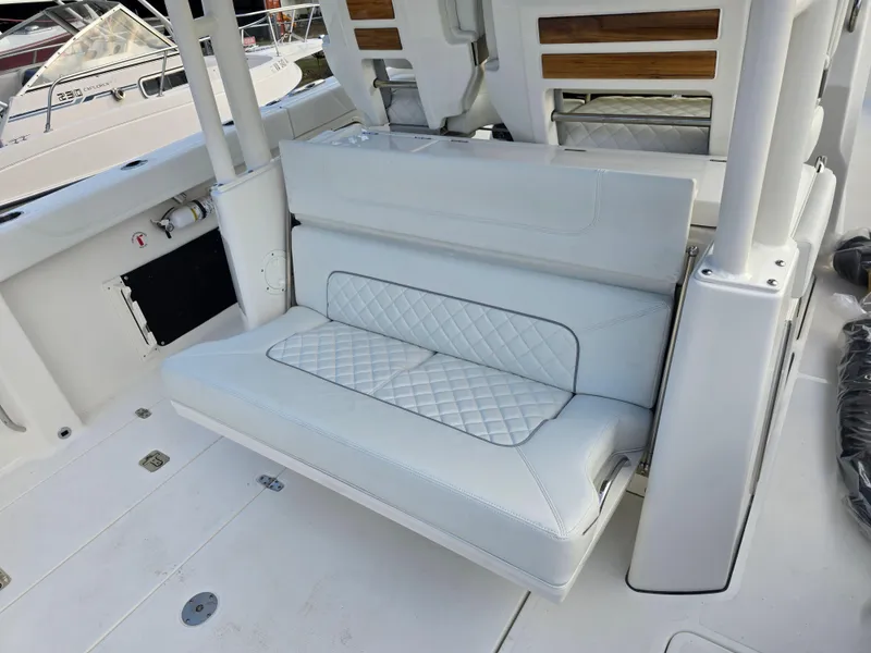 Slide: The Image of 2025 Pursuit S 328 boat interior with white cushioned seating and quilted design. - 9
