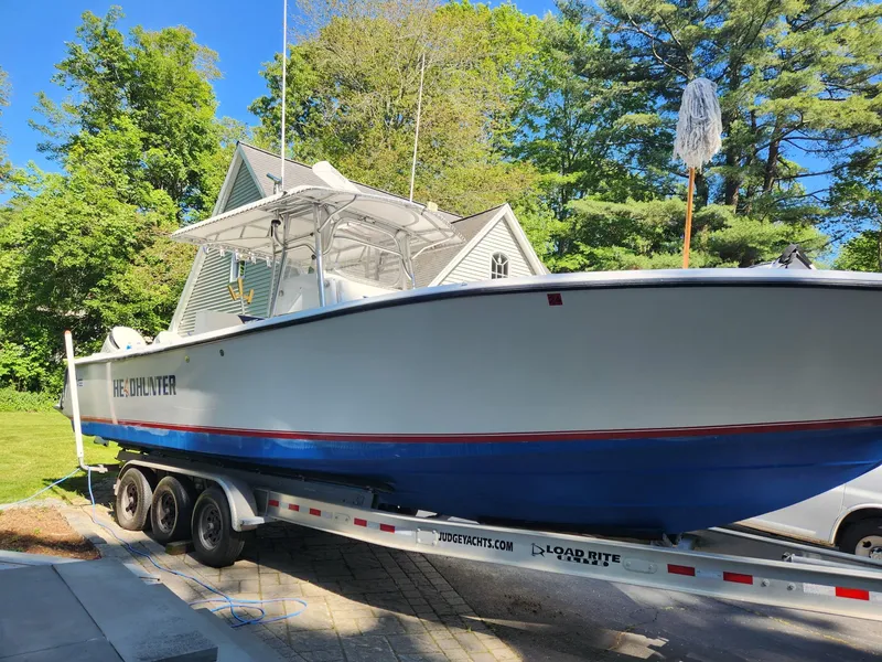 Slide: The Image of 2002 SeaVee Center Console boat on trailer, parked outdoors with trees in the background. - 10