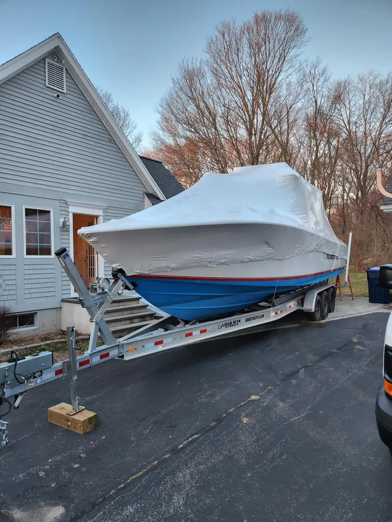 Slide: The Image of 2002 SeaVee Center Console boat covered on a trailer beside a house. - 9