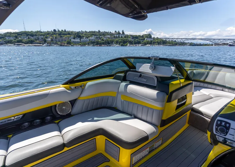 Slide: The Image of 2016 Malibu 24.5 MKZ boat interior with yellow accents on a sunny lake. - 10