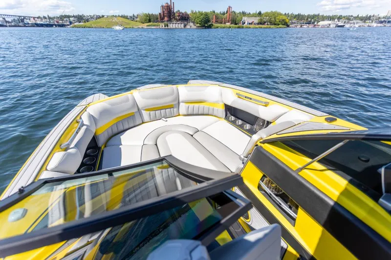 Slide: The Image of 2016 Malibu 24.5 MKZ boat with yellow and white interior on a lake. - 13