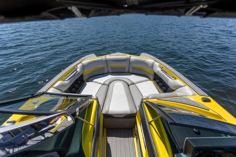 Slide: The Image of 2016 Malibu 24.5 MKZ boat with yellow and gray interior on open water. - 14