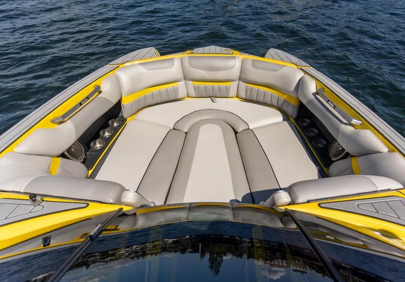 Slide: The Image of 2016 Malibu 24.5 MKZ boat interior with yellow and gray seating on water. - 15