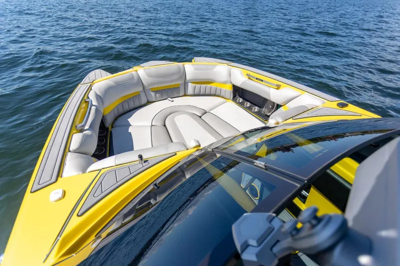 Slide: The Image of 2016 Malibu 24.5 MKZ boat with yellow and gray seating on open water. - 16