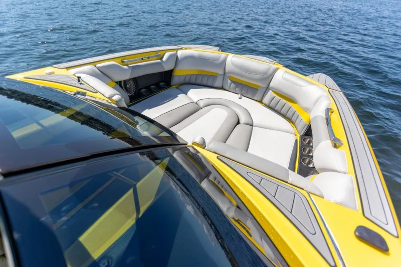 Slide: The Image of 2016 Malibu 24.5 MKZ boat with yellow and gray seating on water. - 17