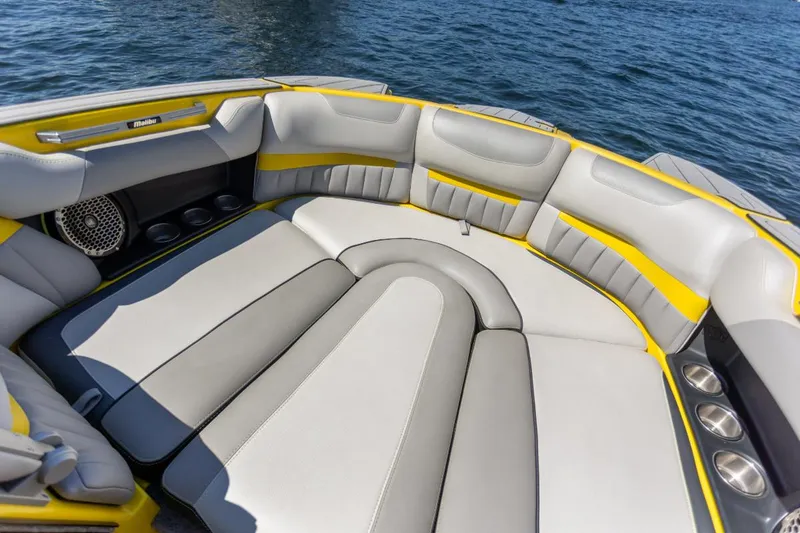 Slide: The Image of Luxurious seating on 2016 Malibu 24.5 MKZ boat, featuring gray and yellow upholstery. - 18